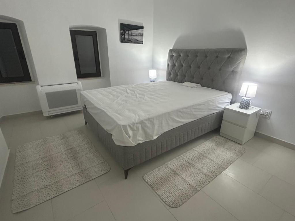 ein Schlafzimmer mit einem großen Bett und zwei Teppichen in der Unterkunft Villa Miramare Perast in Perast