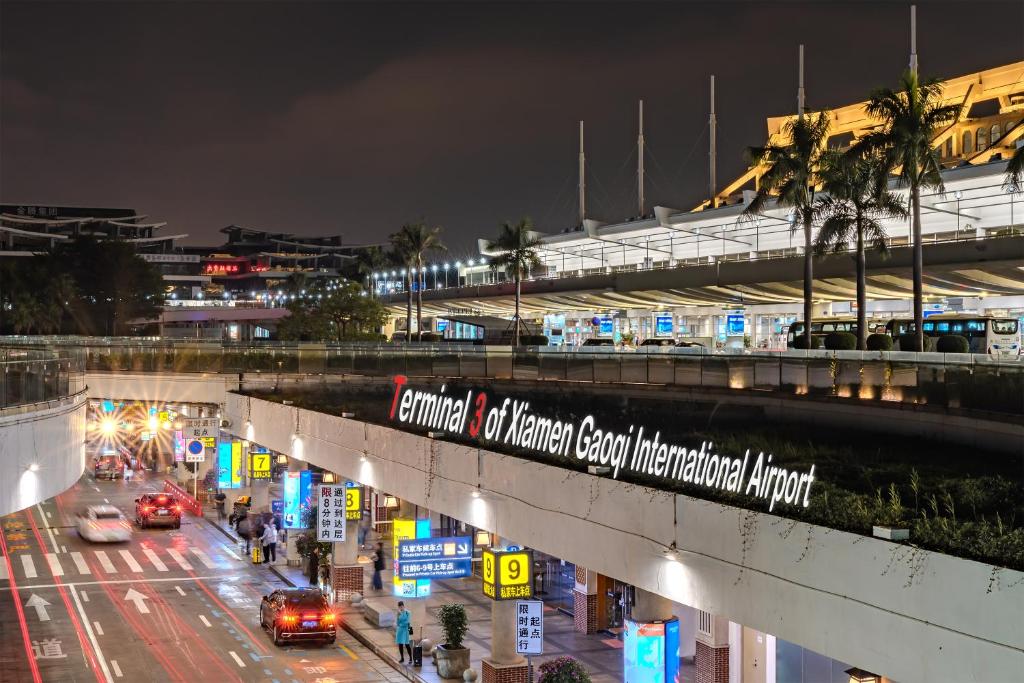 Un cartel en un puente sobre una calle por la noche. en Park Hotel, en Xiamen