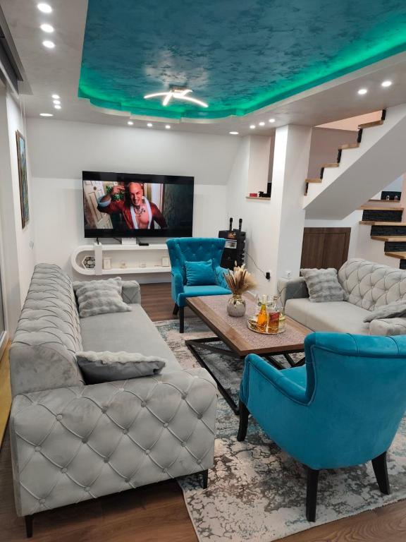 a living room with two couches and a tv at Vila Dunja Pale in Pale