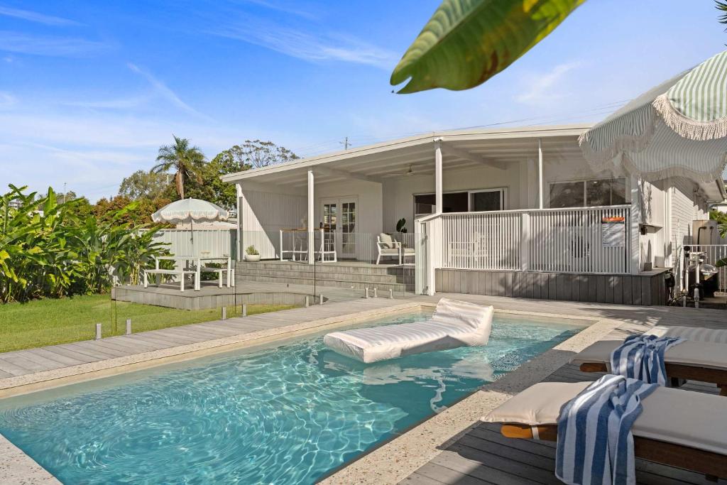 a swimming pool in front of a house at Palm Cove Retreat - Walk to beach & CBD in Maroochydore