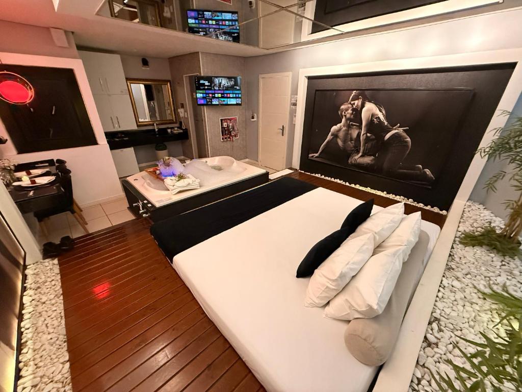 een groot wit bed in een kamer met een tv bij Hotel Motel Paradiso - Panambi-RS in Tabapira