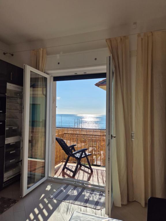 a room with a balcony with a view of the ocean at Alloggio Ametista frontemare con posto auto in Lavagna