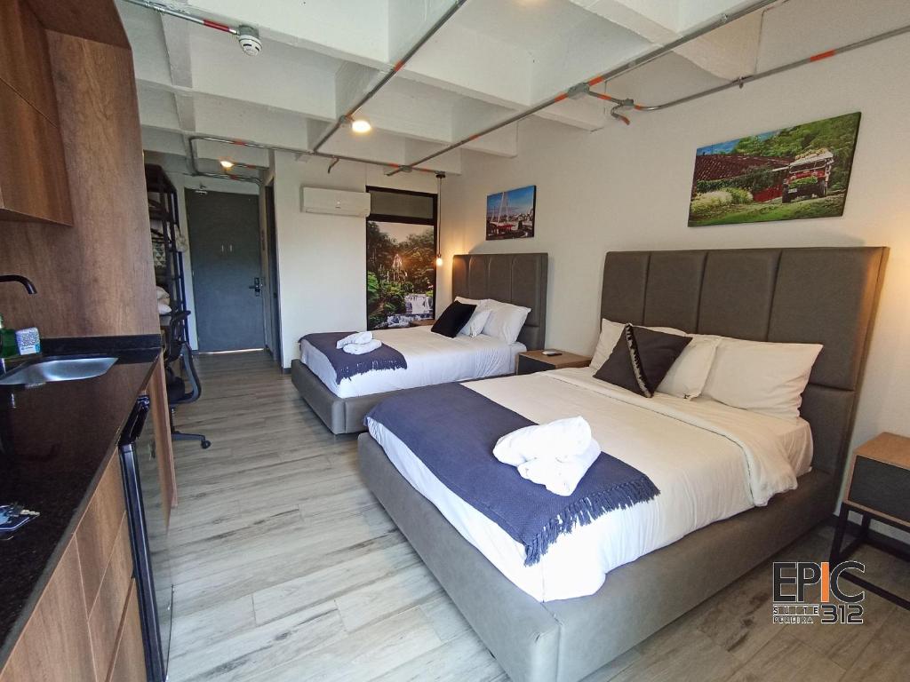 a hotel room with two beds and a sink at Epic Suite 312 Deluxe Airport in Cuba