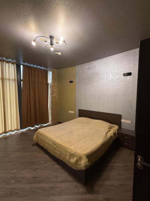 una camera da letto con un letto e un ventilatore a soffitto di LusakertHouse a Nor Gyugh