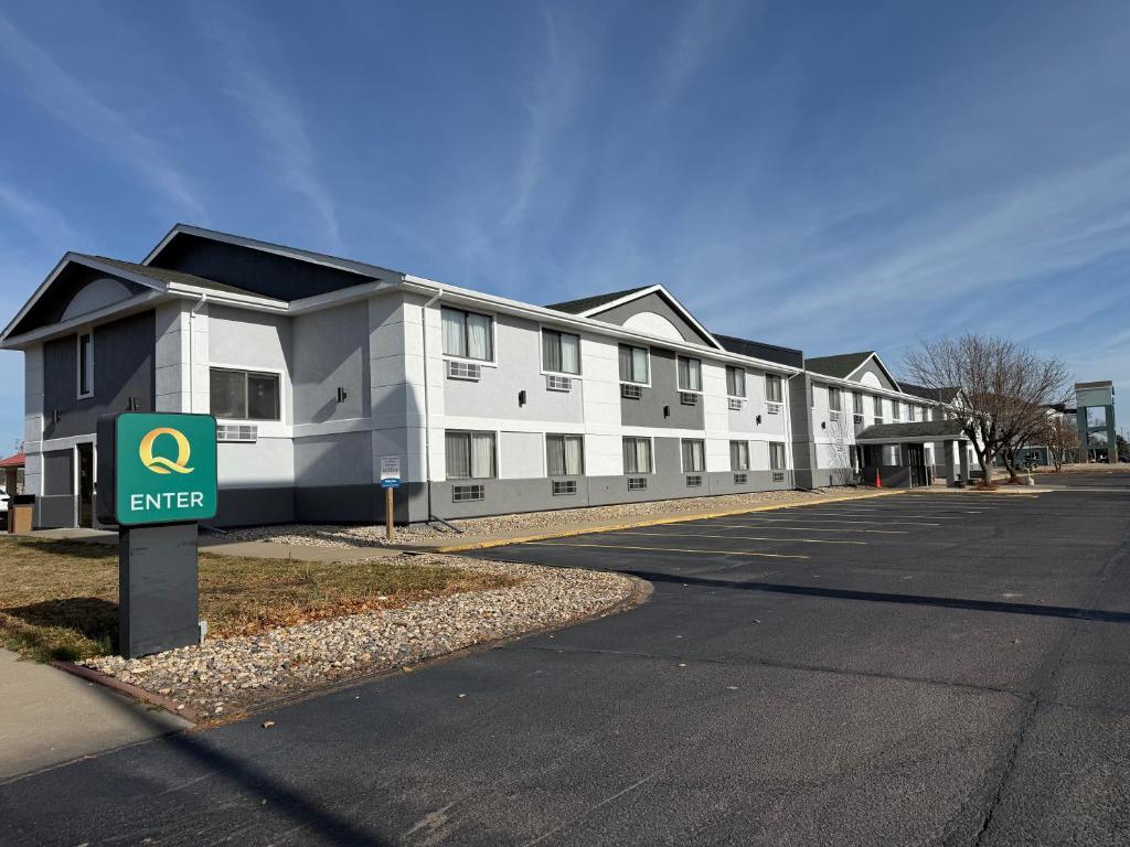 a large white building with a sign in front of it at Quality Inn & Suites Sioux Falls South in Sioux Falls