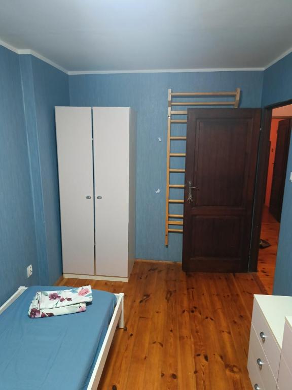 a bedroom with a bed and a wooden floor at Słoneczna Przystań in Wrocław