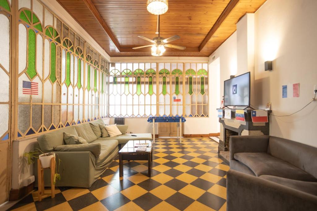 Una sala de estar con un sofá y un televisor. en HOSTEL COLIVING STUDIO JUNIN, en Junín