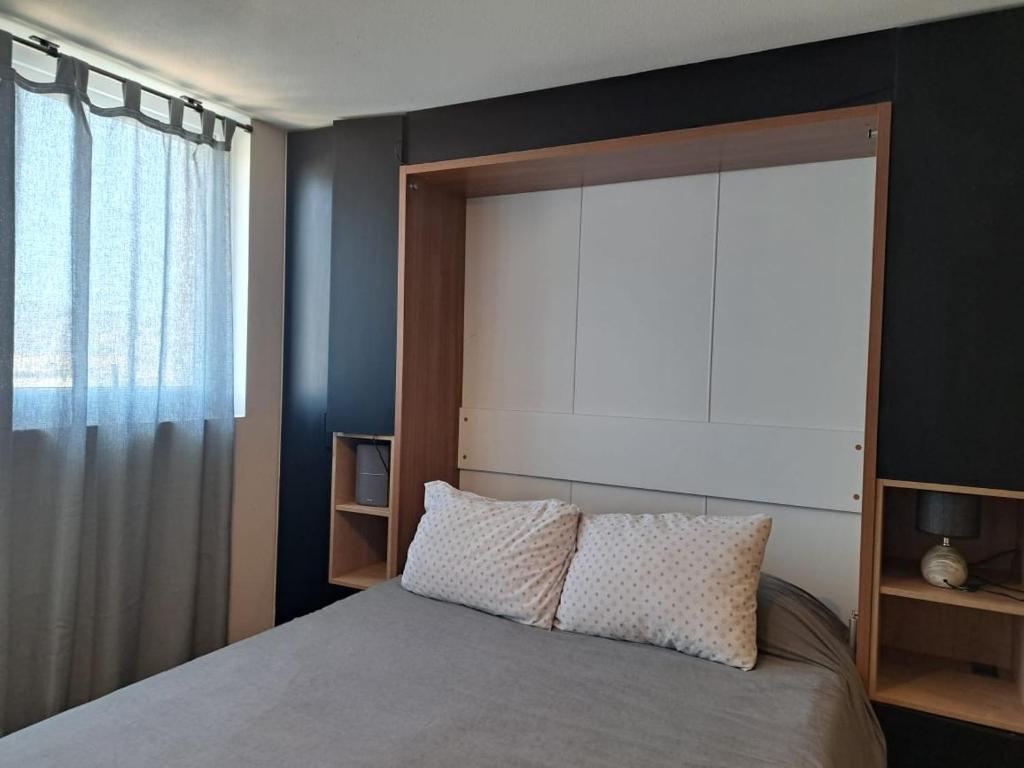 ein Schlafzimmer mit einem Bett mit einem großen Fenster in der Unterkunft Céntrico y preciso en Coquimbo in Coquimbo