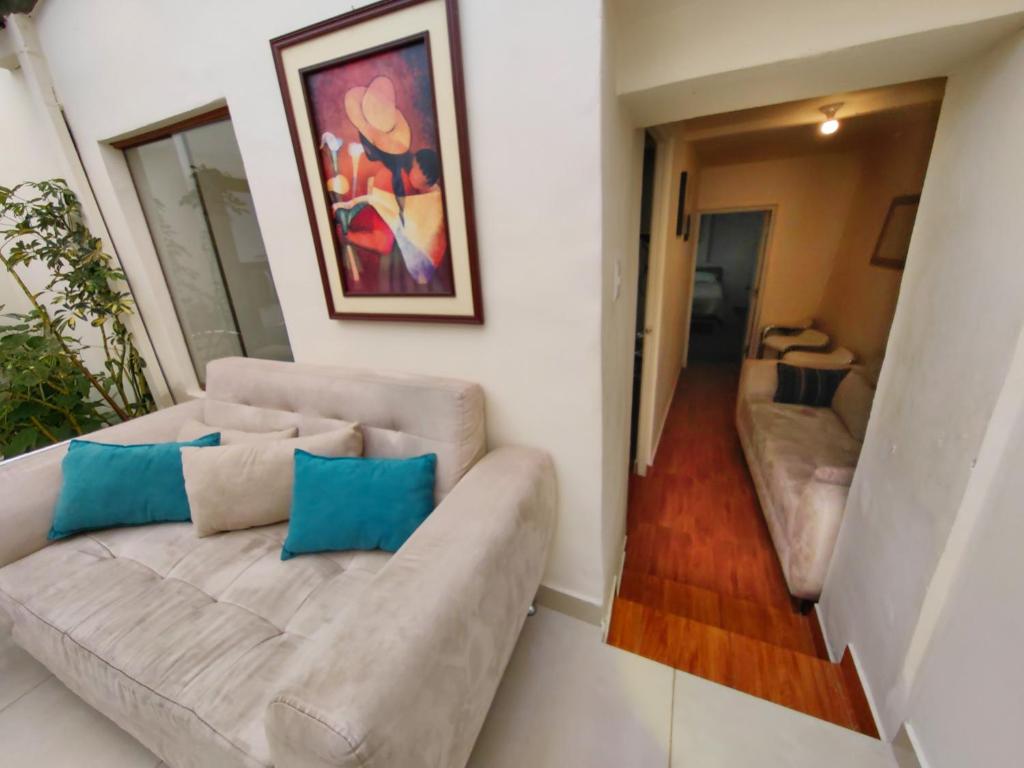 库斯科Centro Cusco Inti的客厅里有一张沙发，上面放着蓝色的枕头