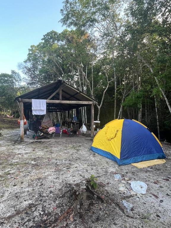 a blue and yellow tent sitting in front of a forest at Paraíso Manancial in Presidente Figueiredo