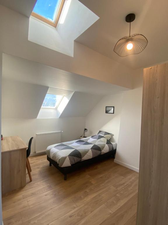 ein Schlafzimmer mit einem Bett und einem Dachfenster in der Unterkunft la maison des copains, garage et wifi in Amiens