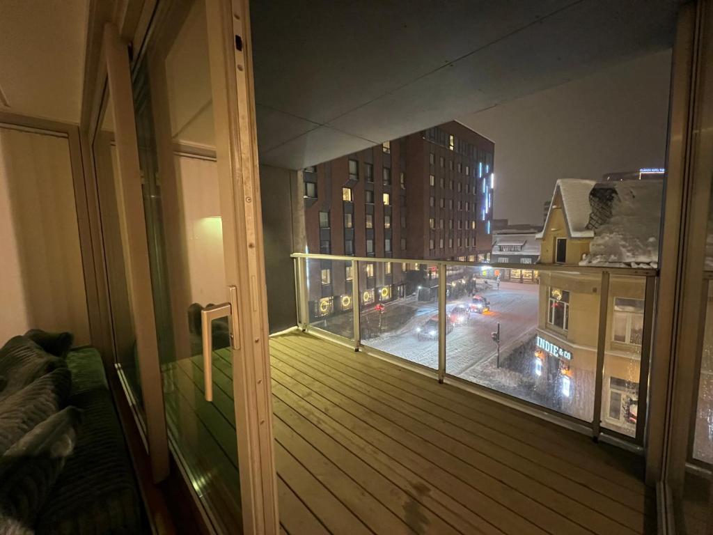 a balcony with a view of a city street at night at Tromsø Central Stay in Tromsø