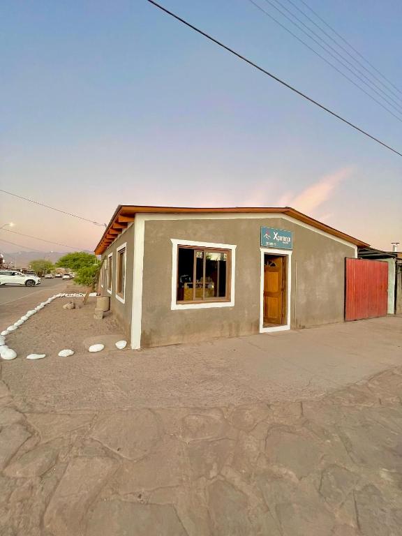 圣佩德罗·德·阿塔卡马Xperience Boutique Art Hostel San Pedro de Atacama的停车场里一栋带窗户的建筑物