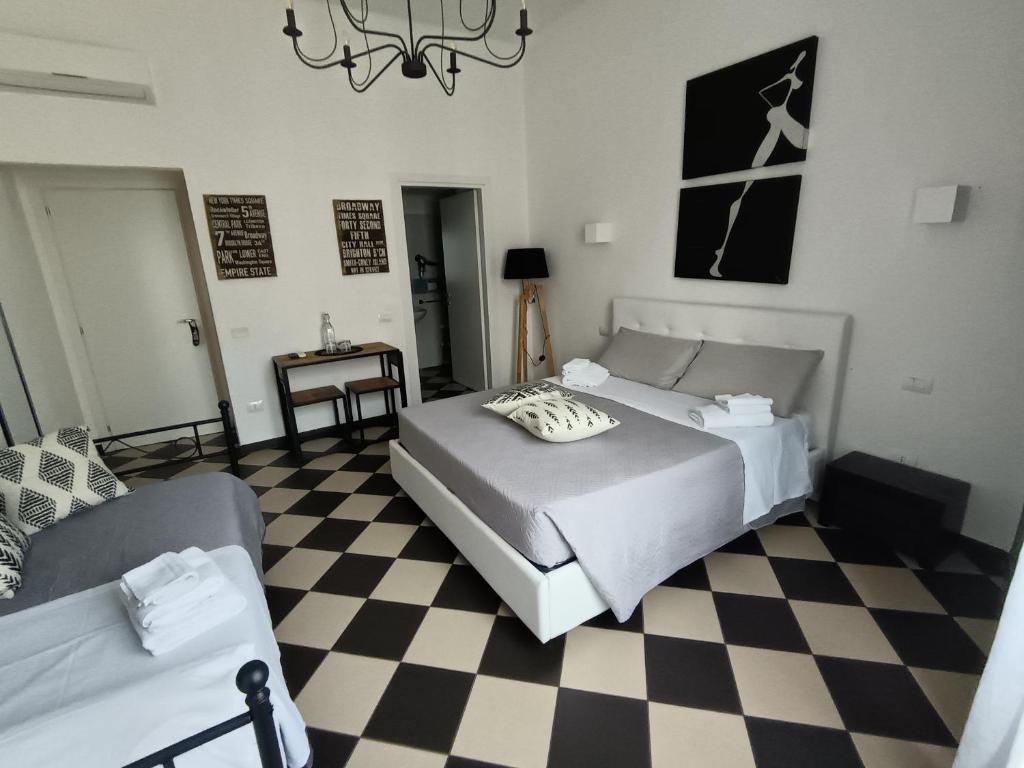 a bedroom with two beds and a checkered floor at Manì Rooms Marina in Cagliari