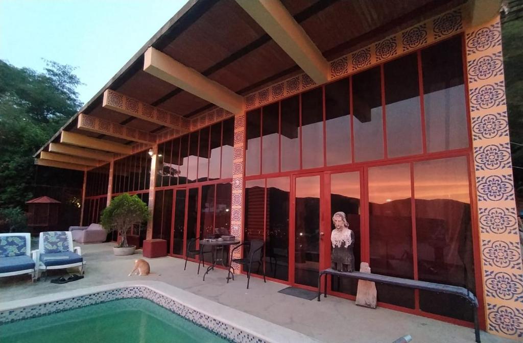 een gebouw met een zwembad ervoor bij Artists loft w panoramic views pool in Taganga