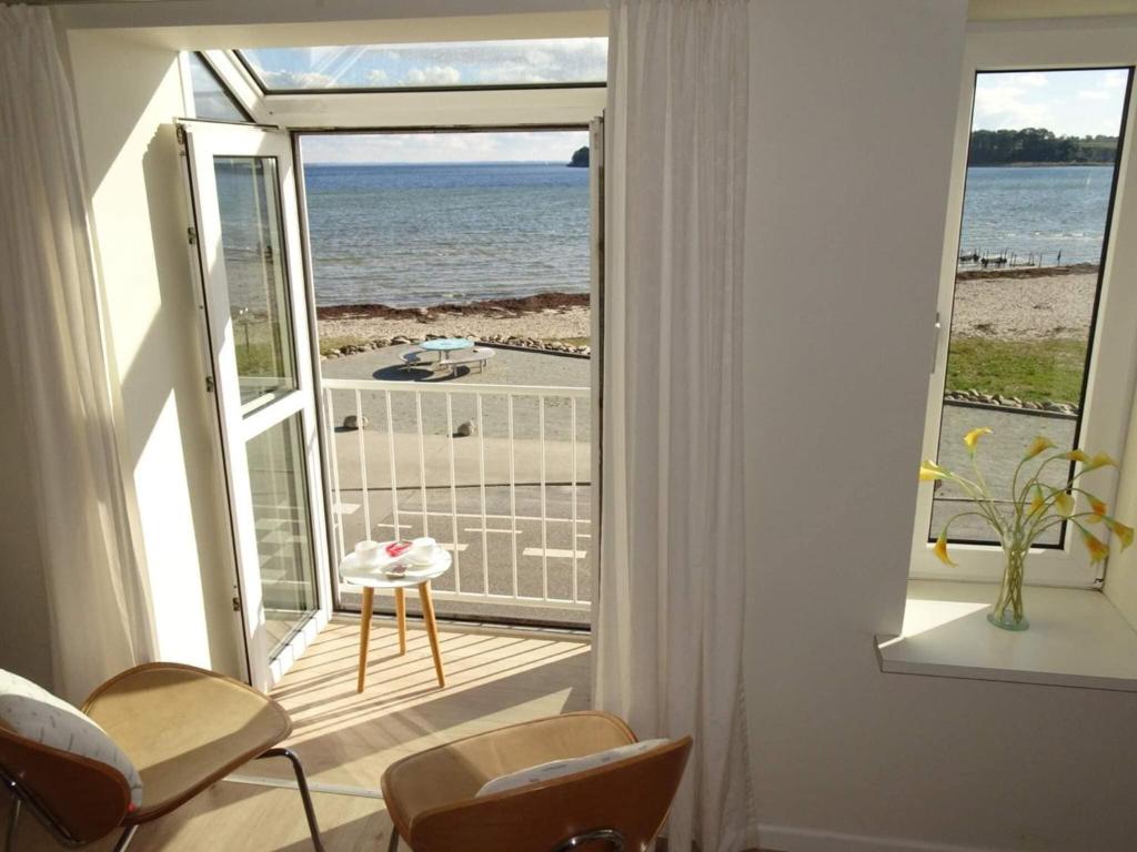 a room with a balcony with a view of the ocean at 4 star holiday home in Hejls in Hejlsminde