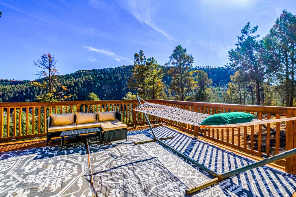 a hammock on a deck with a view of the mountains at Tiny Home with a Huge View in Ruidoso