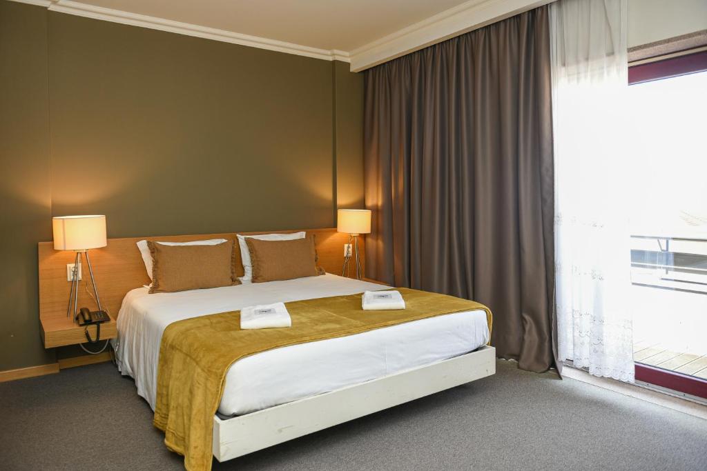 Ένα ή περισσότερα κρεβάτια σε δωμάτιο στο Dom Joao Hotel
