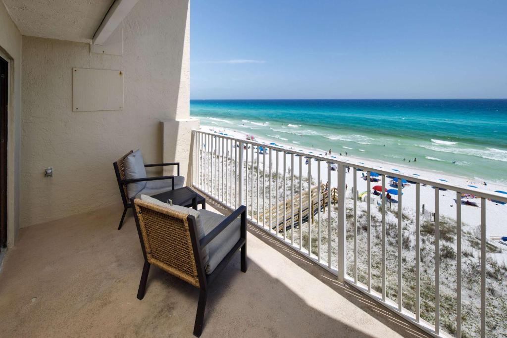 a balcony with two chairs and a view of the beach at Gulf Side 602 Pet friendly gulf front condo in Fort Walton Beach