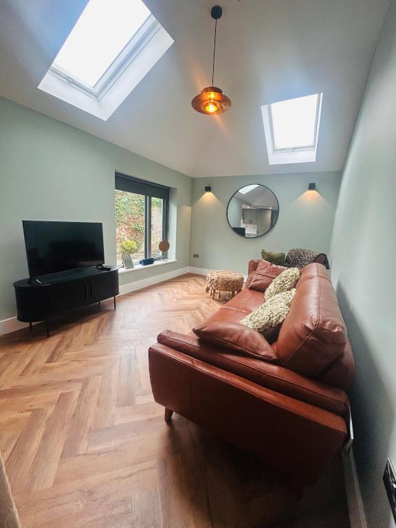 a living room with a couch and a flat screen tv at One bed mews in Dublin