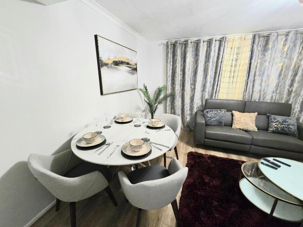 a living room with a table and chairs and a couch at Hornchurch Cozy 2-Bed Flat with Street Parking in Hornchurch