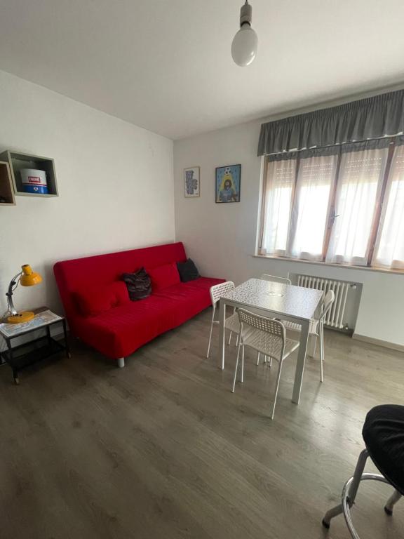 een woonkamer met een rode bank en een tafel bij Eneapolis in Napels
