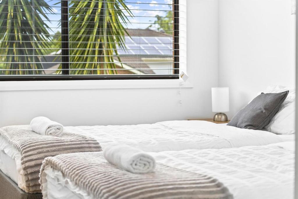 2 camas con toallas en una habitación con ventana en Charming Haven, peaceful stay, en Castle Hill