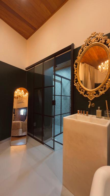 a bathroom with a mirror on the wall and a sink at Pousada Elite in Santa Teresa