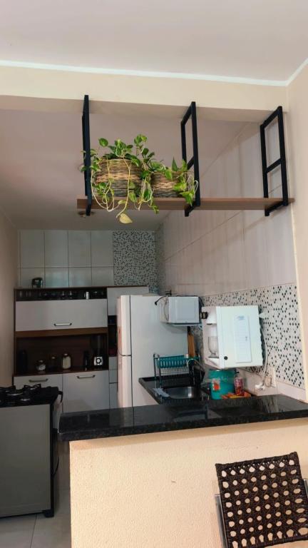 a kitchen with a black counter top and a refrigerator at Casa da paz in Palmas