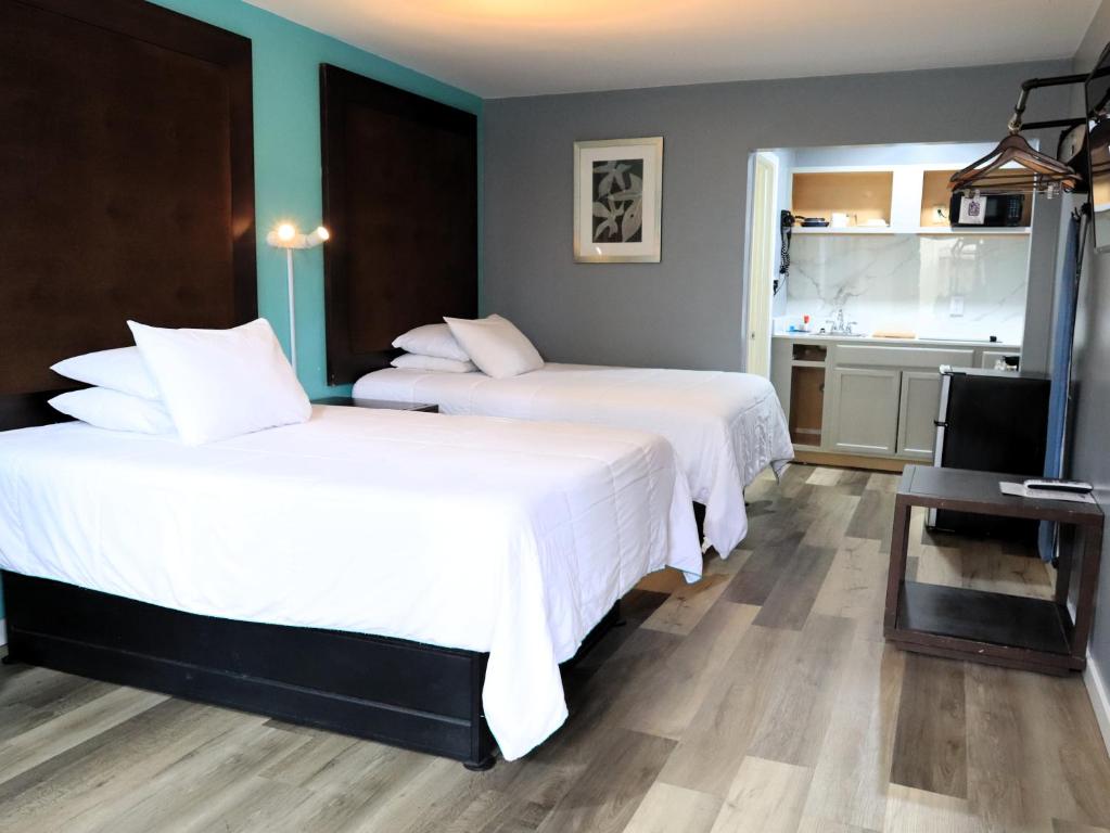 2 letti in camera d'albergo con televisore di Americas Best Value Inn Suites & Studios Blytheville by Sonesta a Blytheville