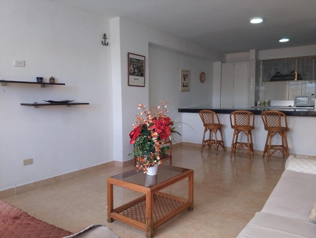 a living room with a couch and a table with flowers at Apartamento Isla de Margarita in Pampatar