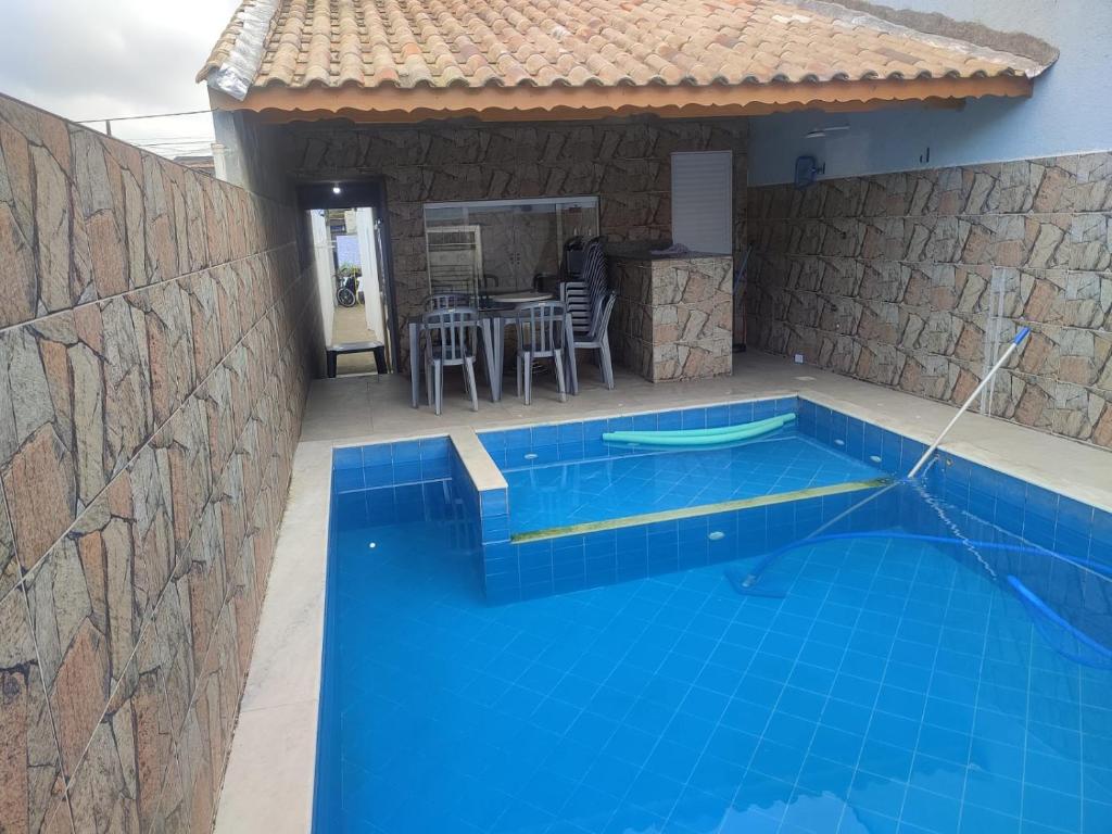 Casa con piscina y mesa con sillas en Casa para temporada 2 Roberto, en Praia Grande