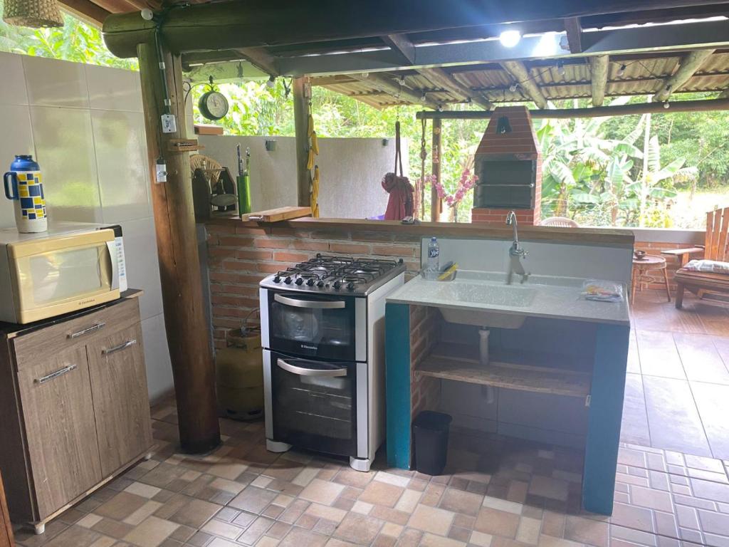 モヘチスにあるCasinhas do Rio - Casinha Azul na Florestaのコンロとシンクのあるキッチン
