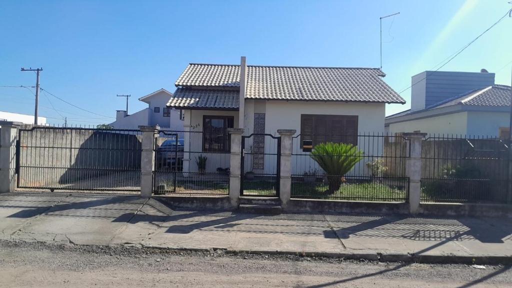 een hek voor een wit huis bij Casa Ana y Ángelo in Pântano Grande