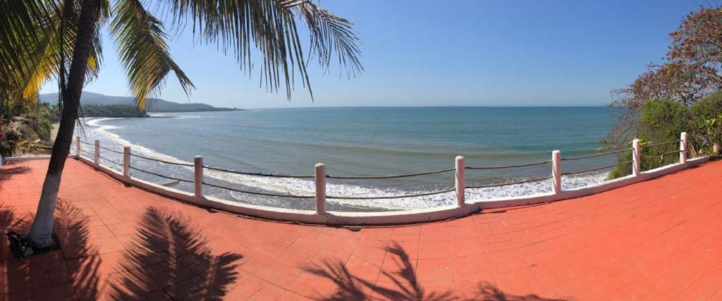 una playa de arena con una valla y el océano en Quinta Charito, Amplia Villa Familiar junto al Mar, en Los Cocos