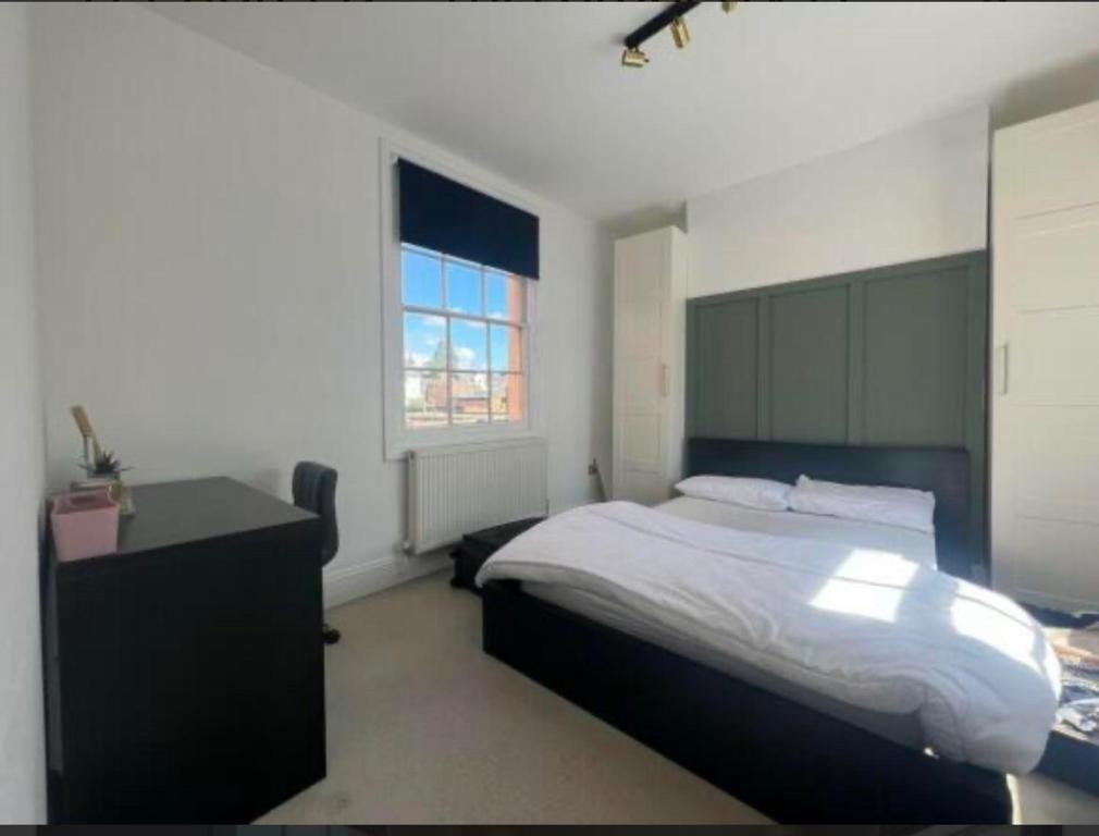 a bedroom with a bed and a desk and a window at Two bed town house in Royal Leamington Spa in Leamington Spa
