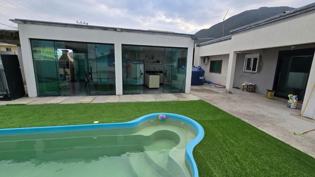 una piscina in un cortile accanto a una casa di Karina Saraiva a Palhoça