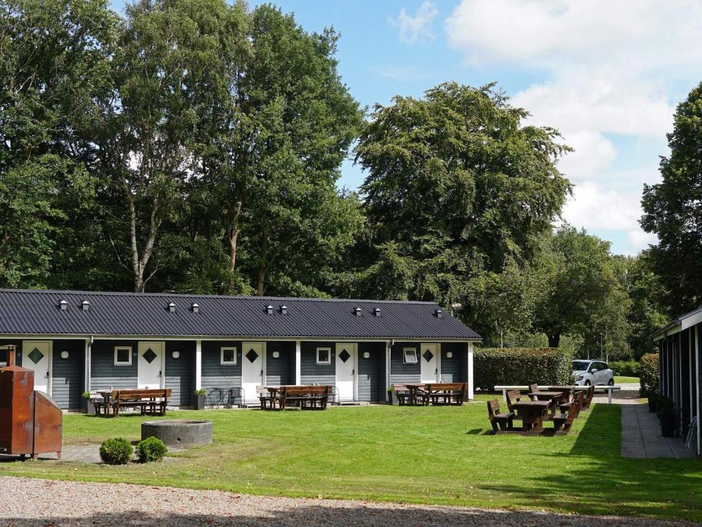 Un edificio con mesas de picnic en el césped. en Scenic cabin near Mariehaven, en Ansager