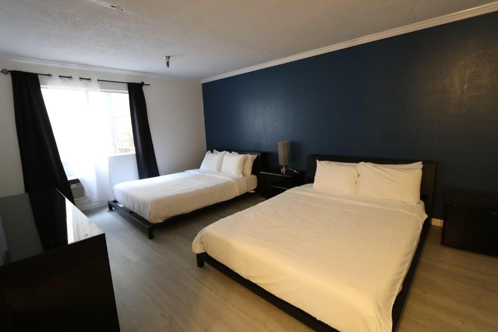 una camera da letto con due letti e una parete blu di Beverly Hills Double Queen apart a Los Angeles