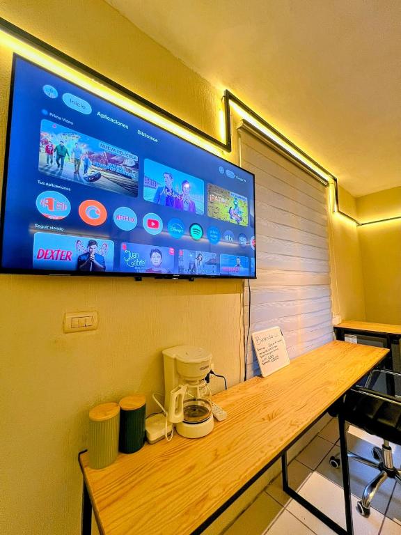 a tv on a wall above a wooden table at Modern Loft #1 in Puerto Barrios