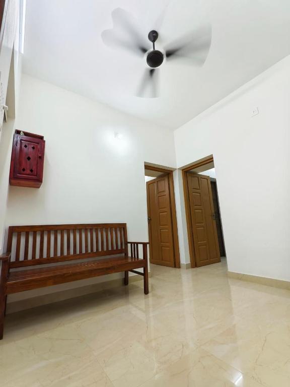 a room with a bench and a ceiling fan at Urban villa in Trivandrum