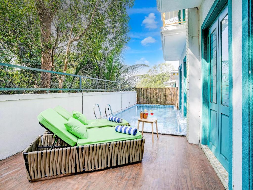 Valencia By DanCenter - 3 Bhk Villa in Siolim في Camorlim: شرفة مع أريكة وحمام سباحة