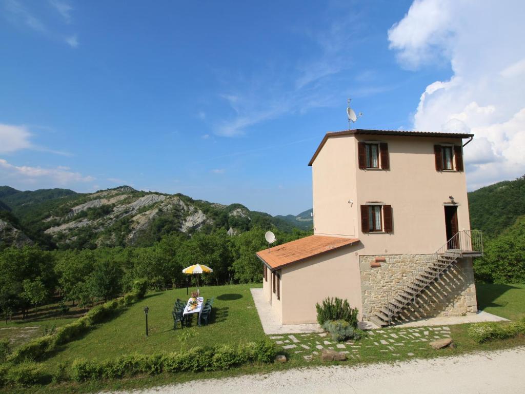 a building with a table and an umbrella next to it at Mansion in Apecchio with Pool in Apecchio
