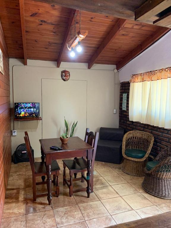 Una sala de estar con una mesa y sillas y un sofá. en Cabañas Canaan, en La Cumbre