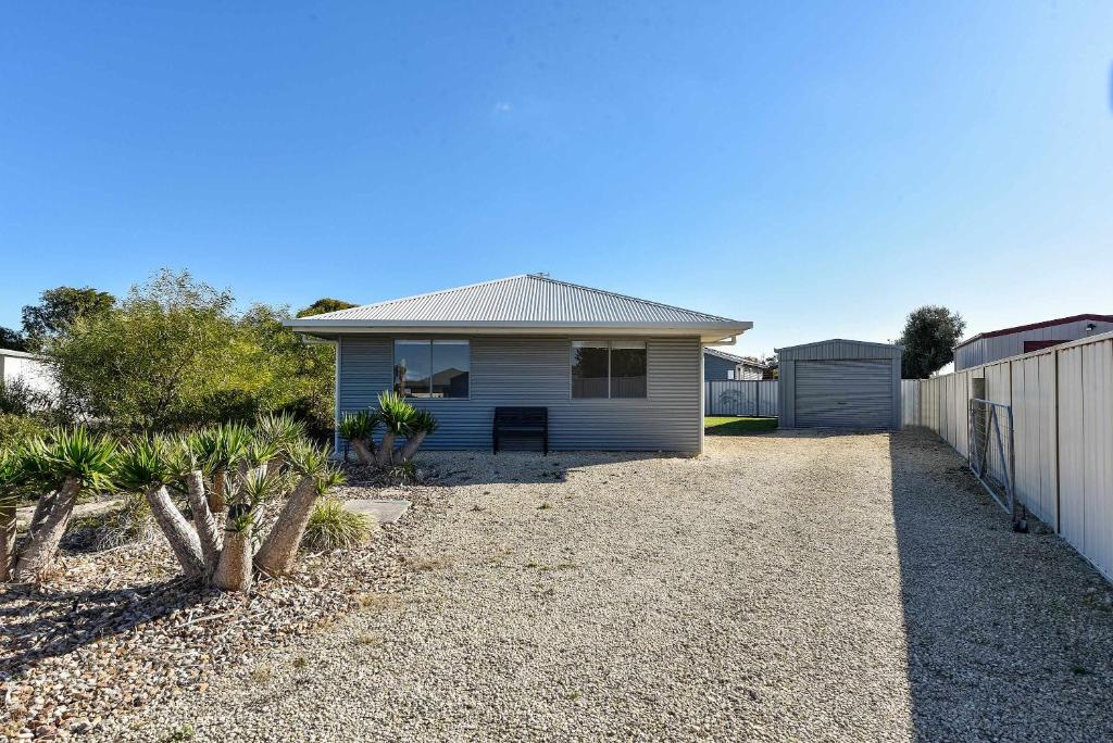 a white house with a fence and a gravel driveway at Solmar Siesta - WiFi Pet Friendly Outside in Robe