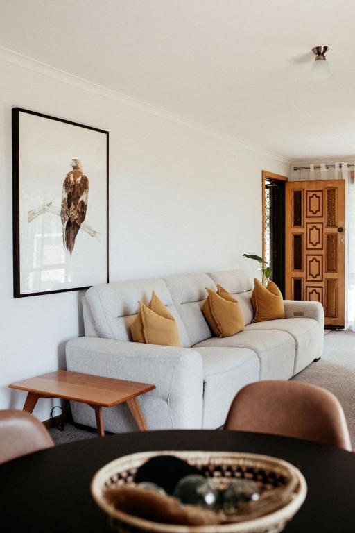 a living room with a white couch and a table at StudioNESS in Scamander