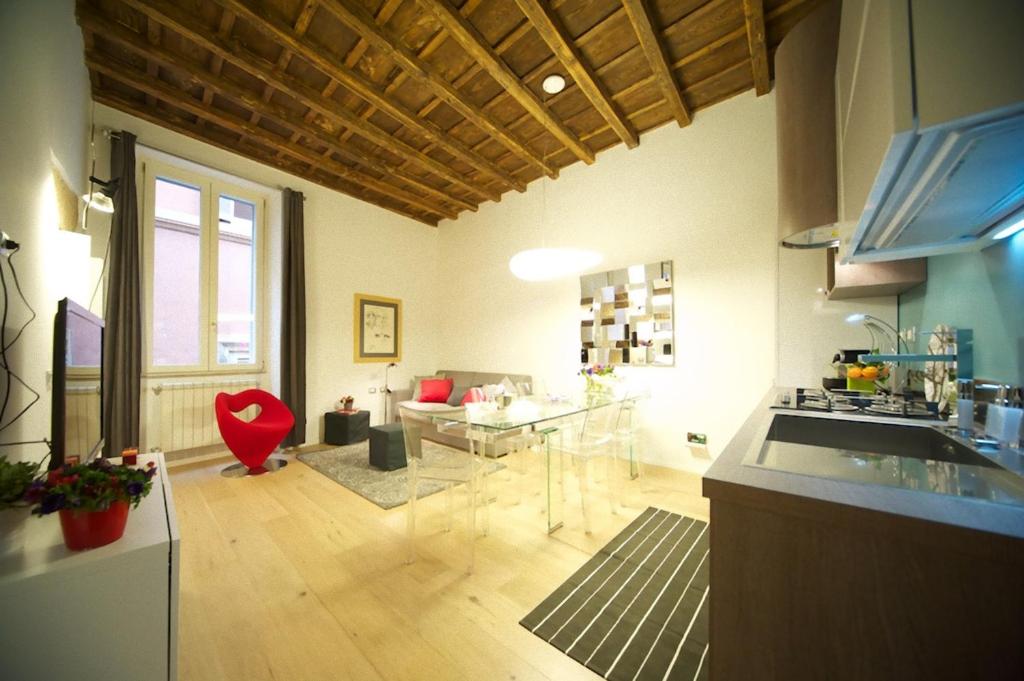 eine Küche mit einem Glastisch und ein Wohnzimmer in der Unterkunft Fico Blu in Rom