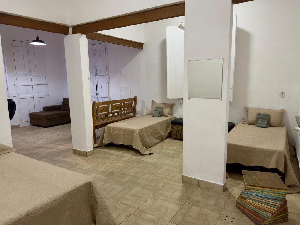 a room with two beds and a couch in it at Casarão Centenário in Passos