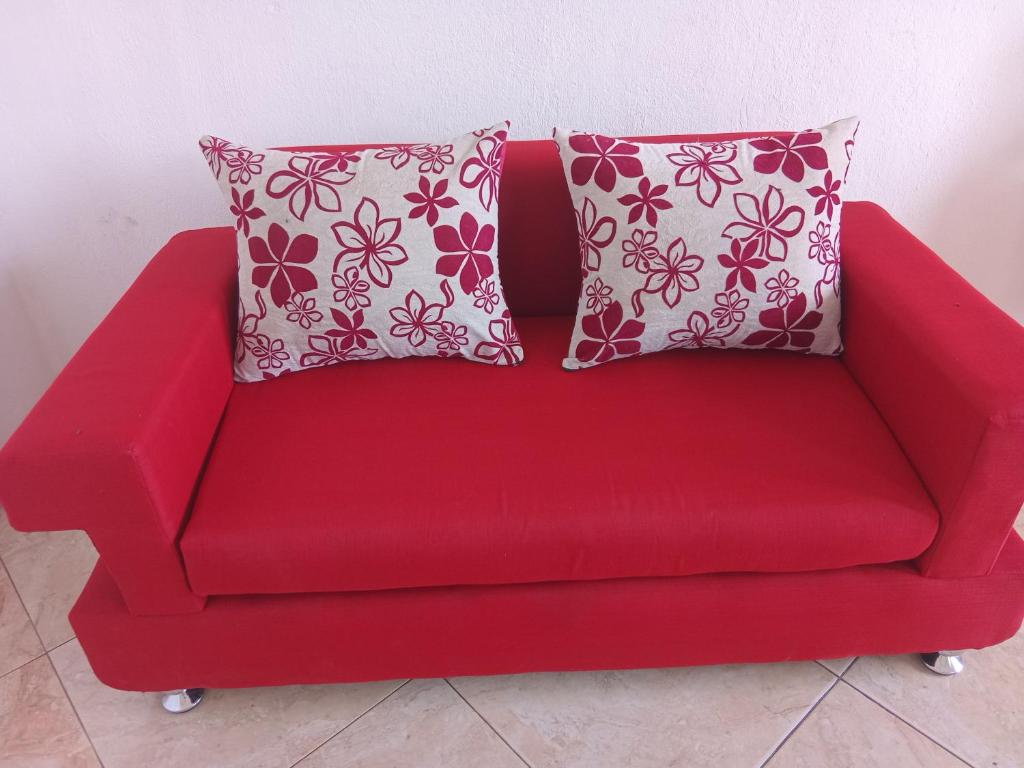 a red couch with two pillows on it at Residence wa maore in Mahajanga