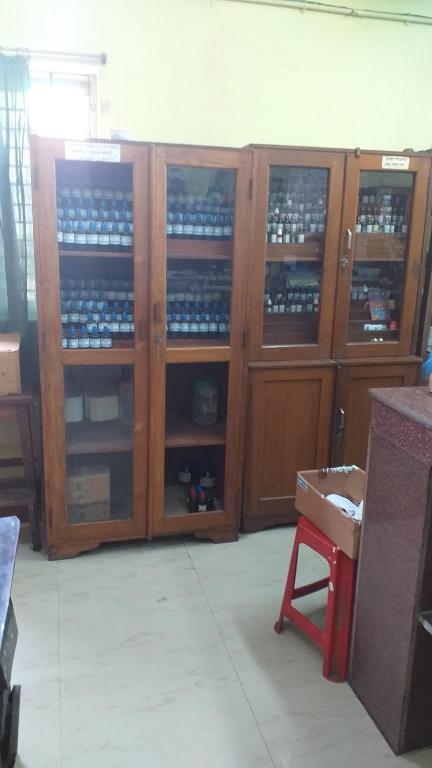 a room with wooden cabinets filled with bottles at Dr A Amin Homeopathy Clinic in Kolkata